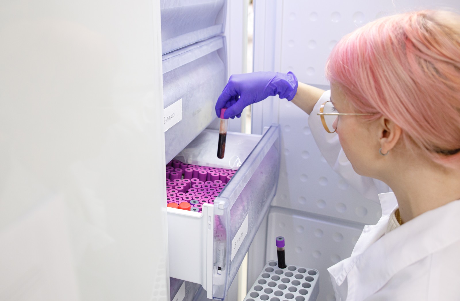 Scientist putting away vials in fridge